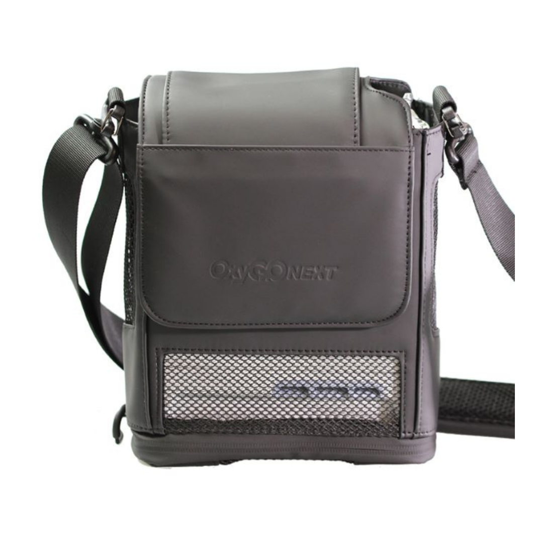 The OxyGo NEXT Carry Bag with Shoulder Strap is a gray, rectangular bag featuring a front mesh pocket, adjustable storage strap, embossed OxyGo NEXT logo on the flap, and heat ventilation for safe medical equipment transport.